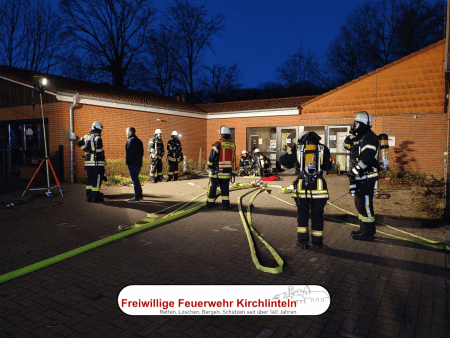 Ausgerüstete Trupps mit Atemschutz vor dem Haupteingang