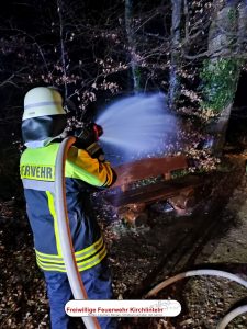 Feuerwehrmann löscht mit einem Hohlstrahlrohr das Feuer